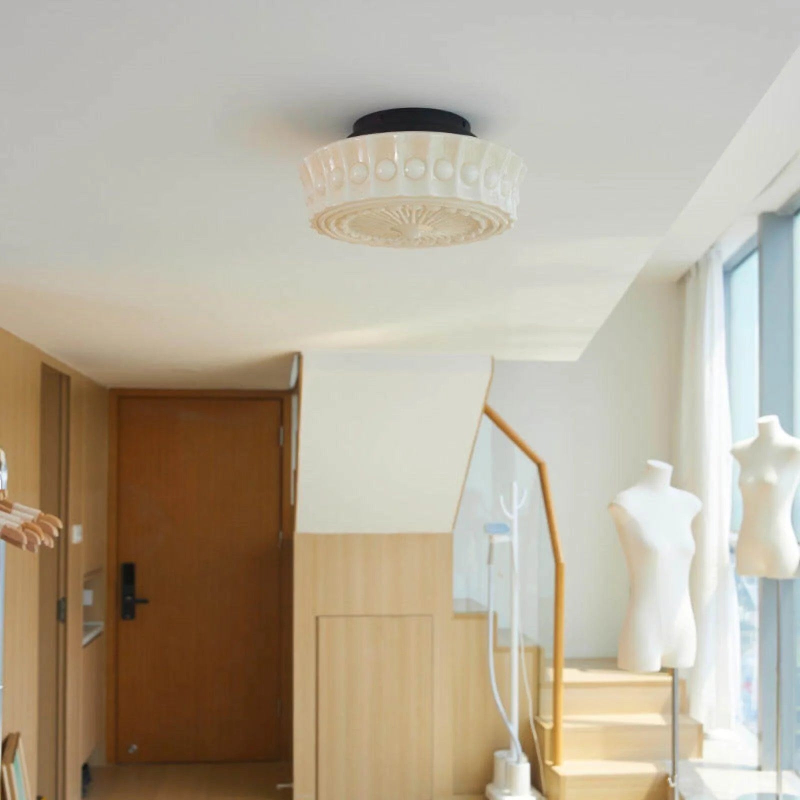 French vintage style flushmount ceiling light with a decorative textured glass shade and black base, installed in a bright, modern interior space.