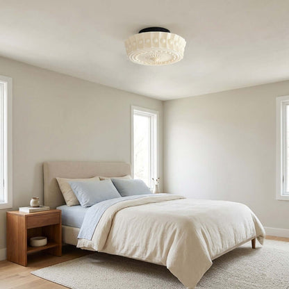 French vintage flushmount ceiling light with a decorative fluted glass shade installed in a neutral-toned bedroom with a linen bed and wooden furniture.