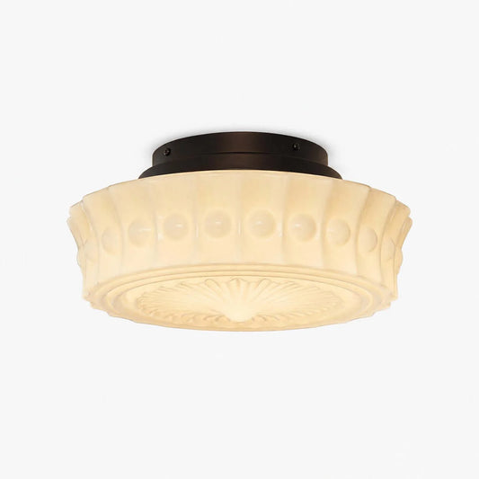 French vintage flushmount ceiling fixture featuring a cream-coloured glass shade with a textured pattern and a dark circular base for indoor lighting.