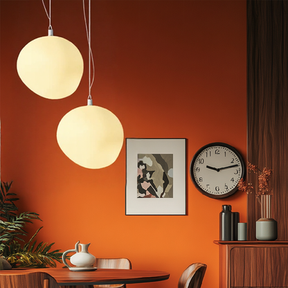 Two globe pendant lights in a warm red interior
