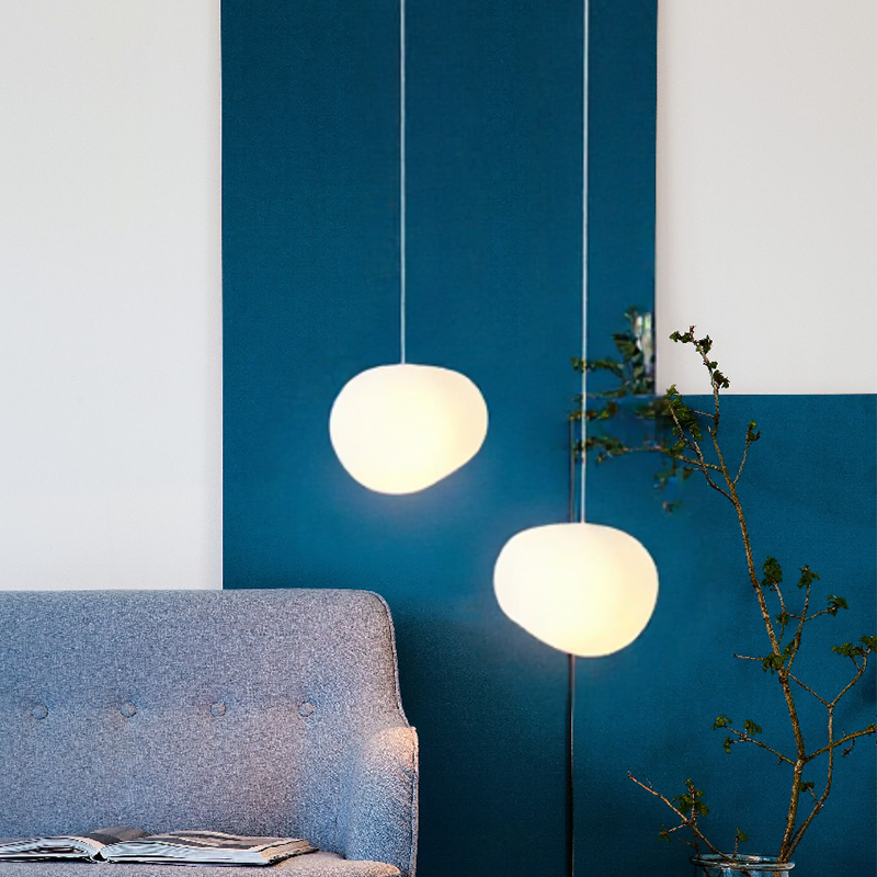 Warm globe pendant lights above a sofa