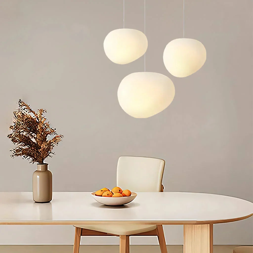 Three warm glass globe pendants above a dining table