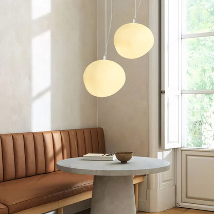 Two illuminated glass globe pendants beside a window
