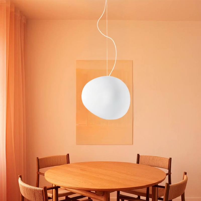 White globe pendant above a round wooden table