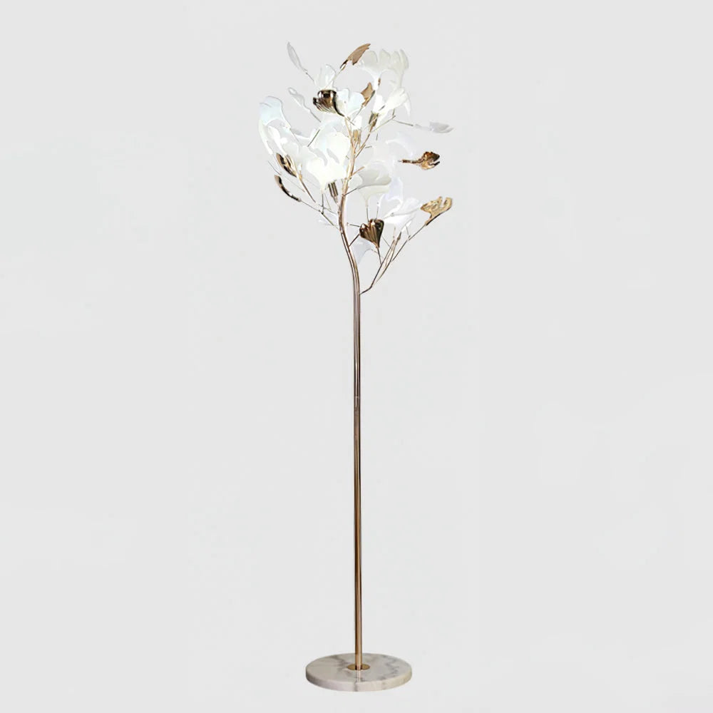 A modern ginkgo leaf LED floor lamp featuring a slender gold-coloured stem, a round marble base, and delicate white and gold leaf-shaped shades.