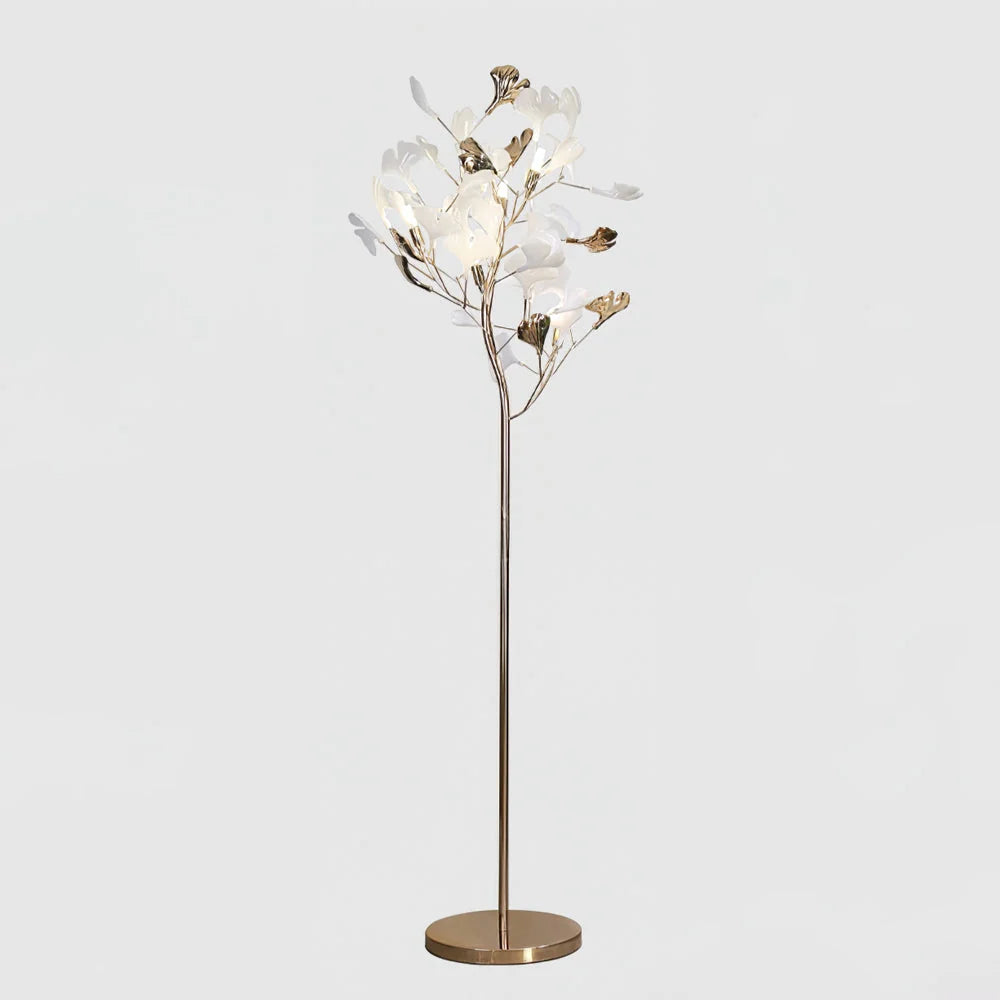 An elegant gold LED floor lamp featuring a branch-like design with illuminated white and gold ginkgo leaves on a circular base.