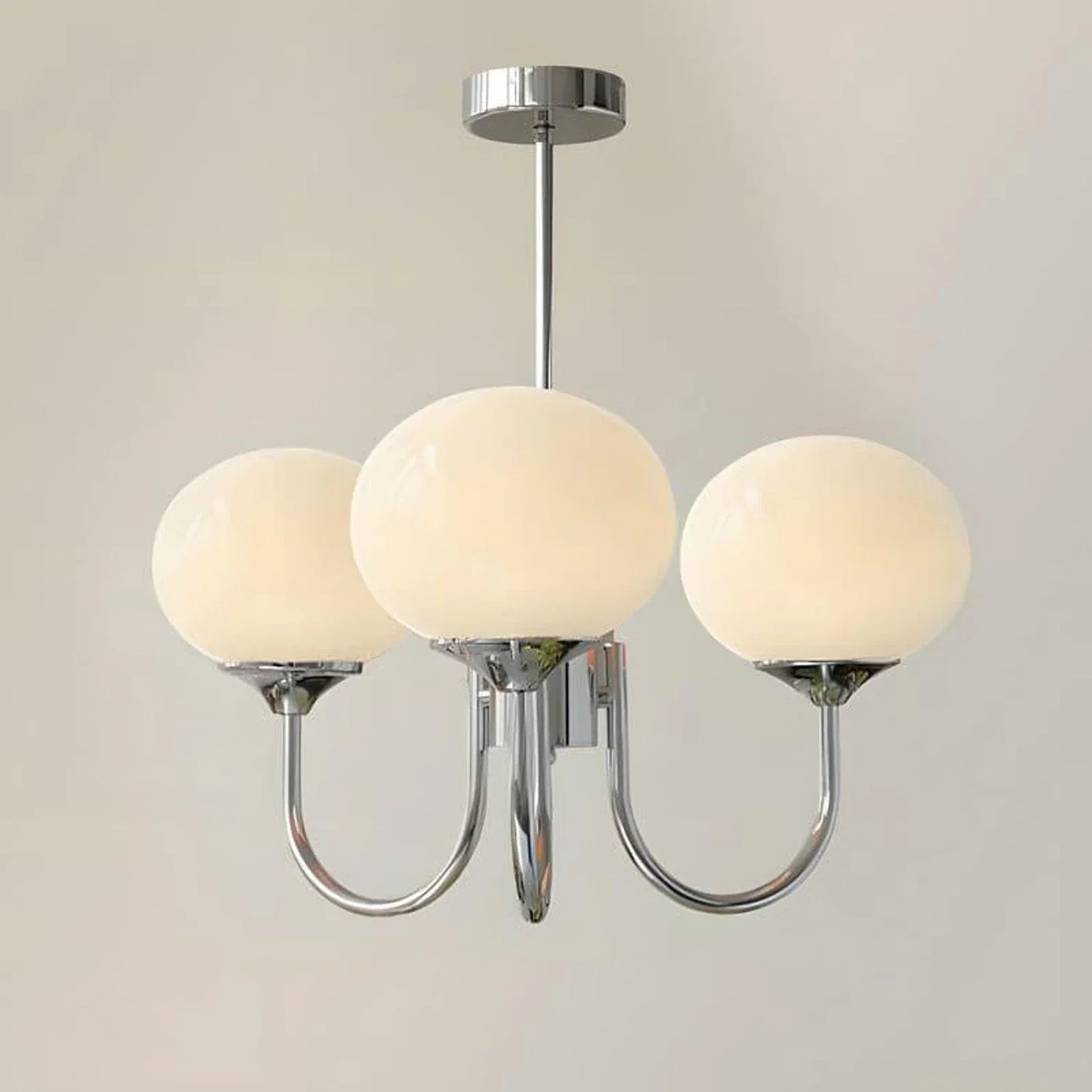 A modern 3-light pendant ceiling light featuring a polished chrome metal frame and three spherical white glass ball shades against a neutral background.