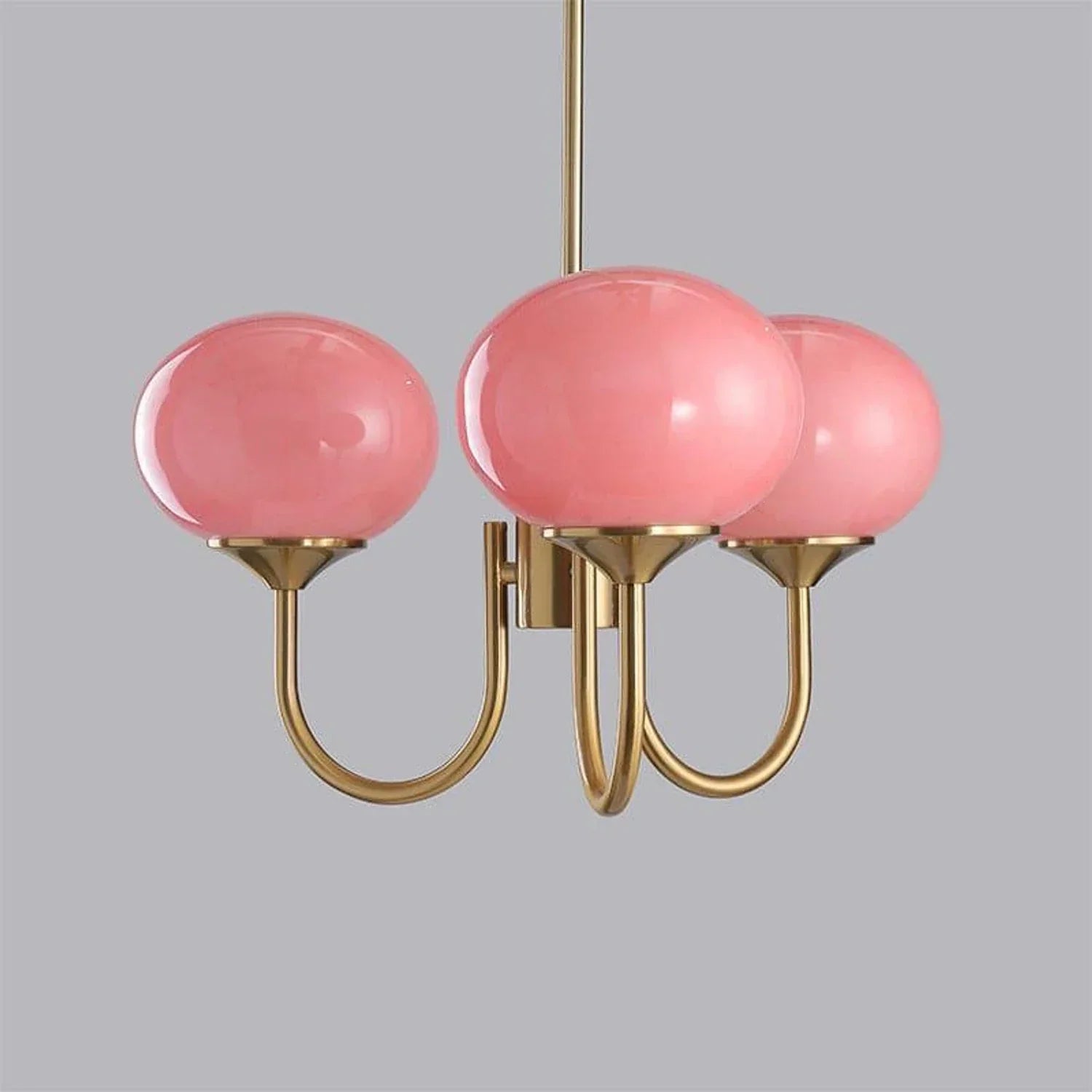A modern 3-light pendant ceiling fixture featuring three glossy pink glass ball shades supported by curved copper-finished metal arms.