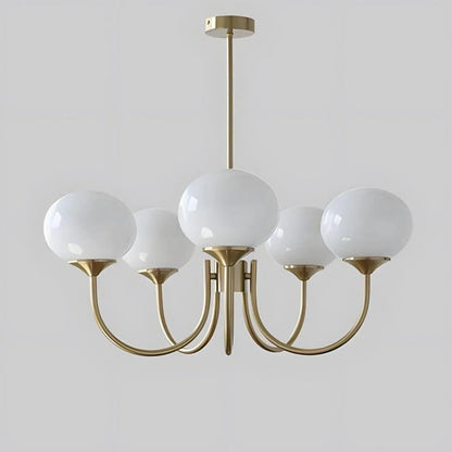 A modern 5-light pendant ceiling fixture featuring five white glass globe shades on curved brass-coloured metal arms against a plain grey background.