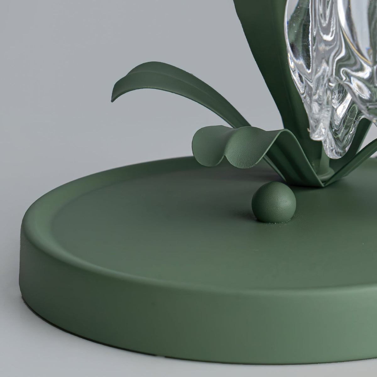 Green circular lamp base with sculpted metal leaf detailing