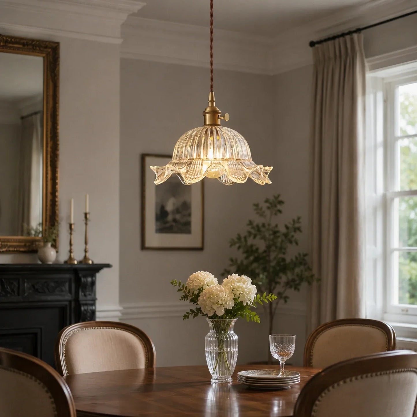 Small glass pendant light with a fluted shade and adjustable cord hanging above a wooden dining table in a traditional room with elegant decor.