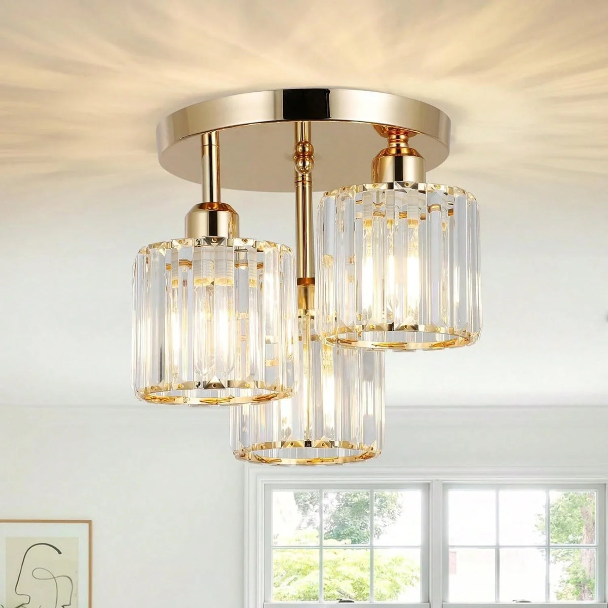 Close-up of gold 3-light semi-flush ceiling light with clear glass shades