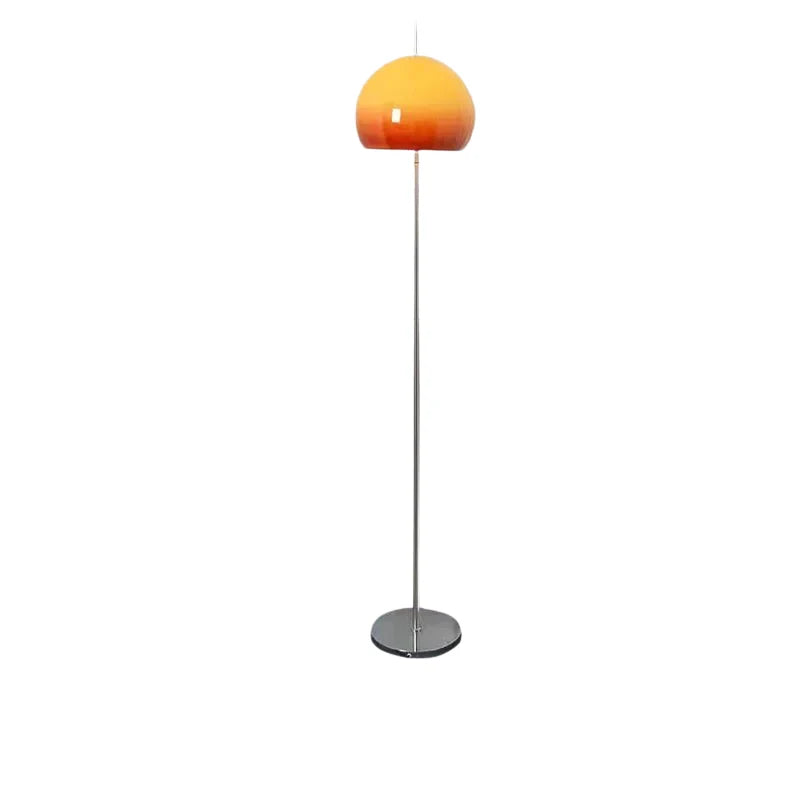 A mid-century modern floor lamp featuring a slim chrome stand and a dome-shaped gradient orange glass shade, isolated on a white background.