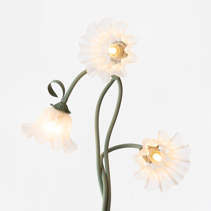 Three white flower shades with visible bulb fittings