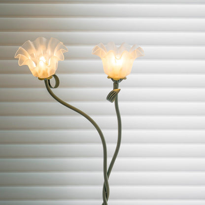 Two-head flower lamp viewed against window blinds