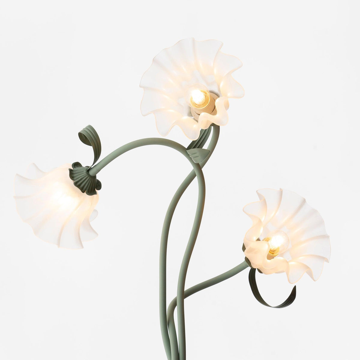 Close-up of three illuminated white flower shades