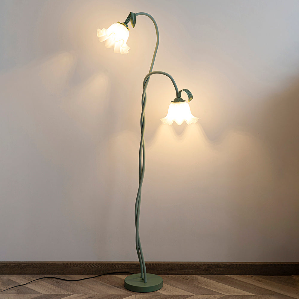 Two-head flower floor lamp casting warm light onto a wall