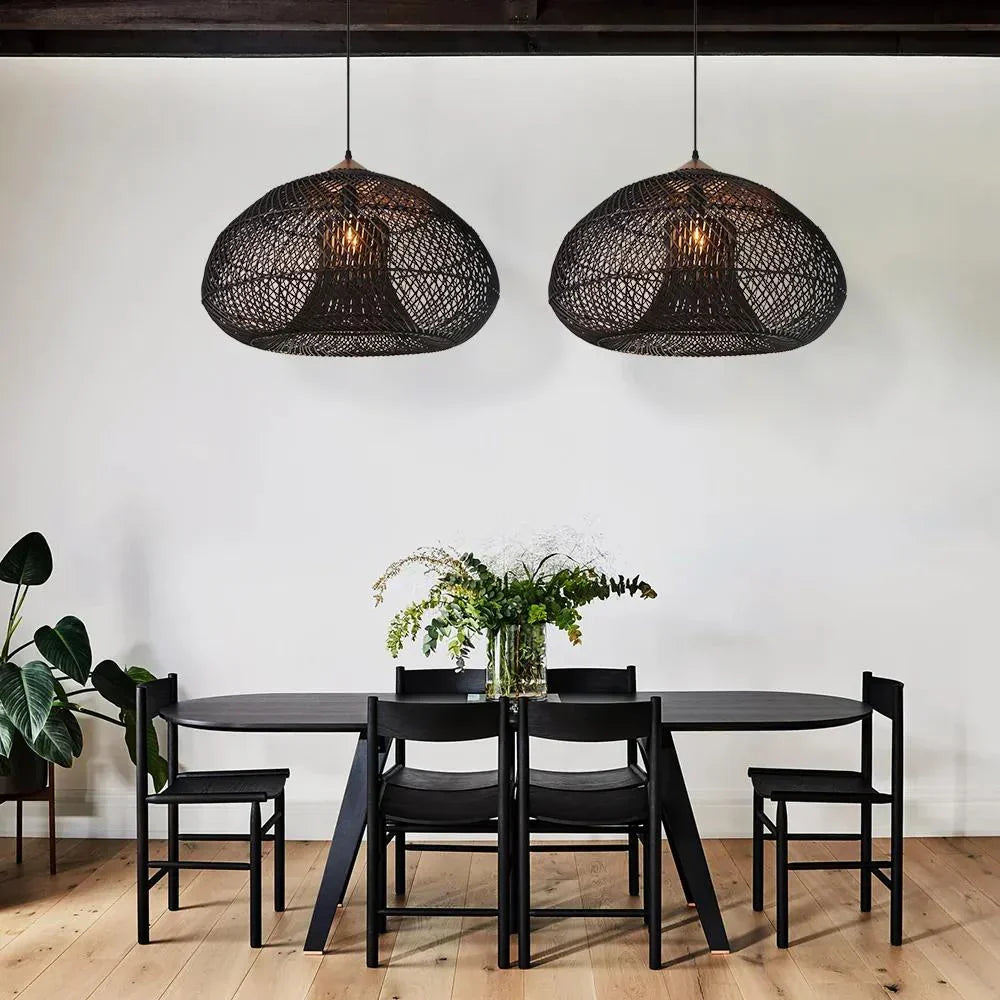 Two dark woven dome pendants above a round table