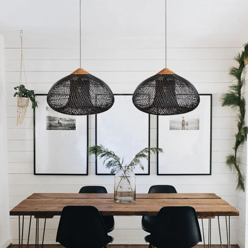Two black rattan pendants above a wooden table