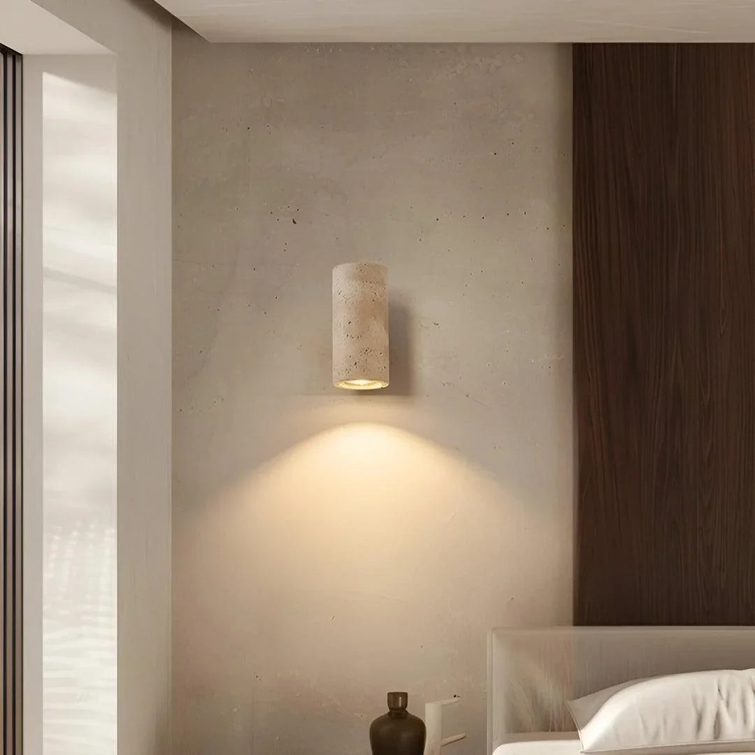 Compact travertine wall light beside a bed