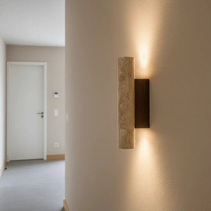 Travertine cylinder wall light in a hallway
