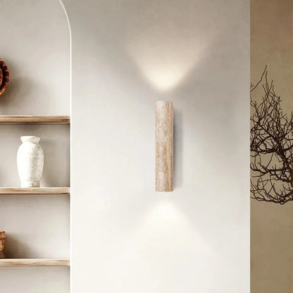 Up-and-down travertine wall light beside open shelving