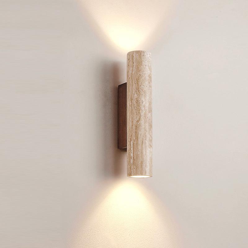 Close-up of travertine wall light with warm up-and-down glow