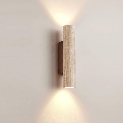Close-up of travertine wall light with warm up-and-down glow