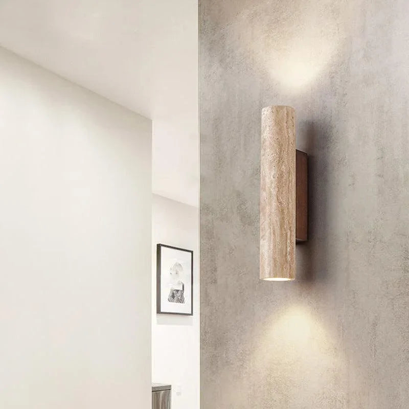 Travertine cylinder wall light on a textured wall