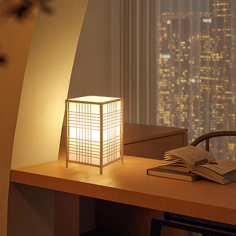 Japanese-style bamboo table lamp on a shelf beside books