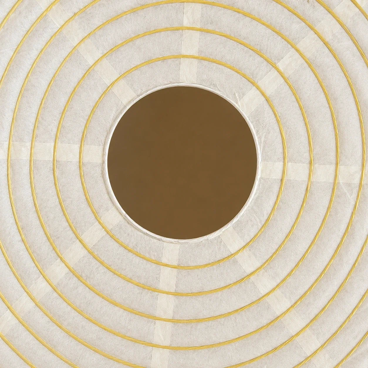Close-up detail of a Japanese paper globe pendant light, showcasing the textured white paper shade with concentric yellow wire rings and a central opening.