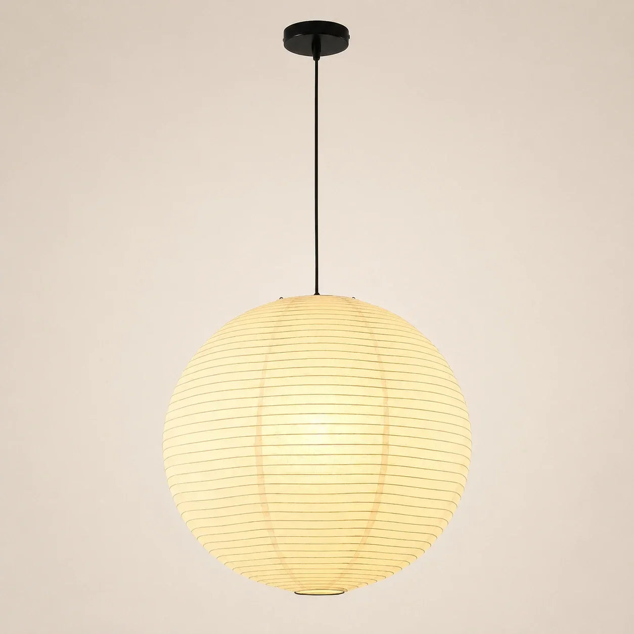 Minimalist Japanese-style globe pendant light featuring a round paper lantern shade suspended by a thin black cord and matching ceiling rose.