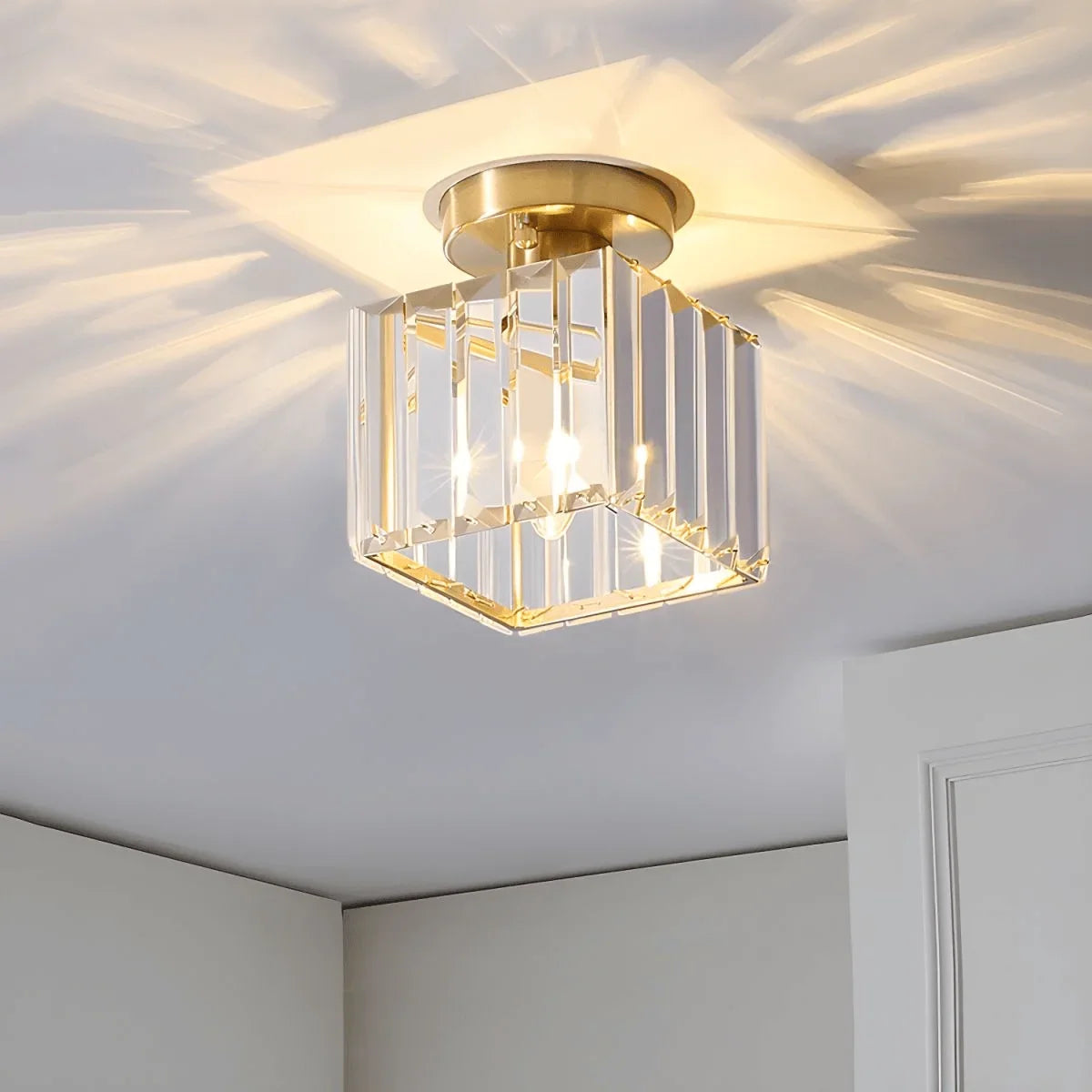 Gold square crystal light casting a ceiling pattern