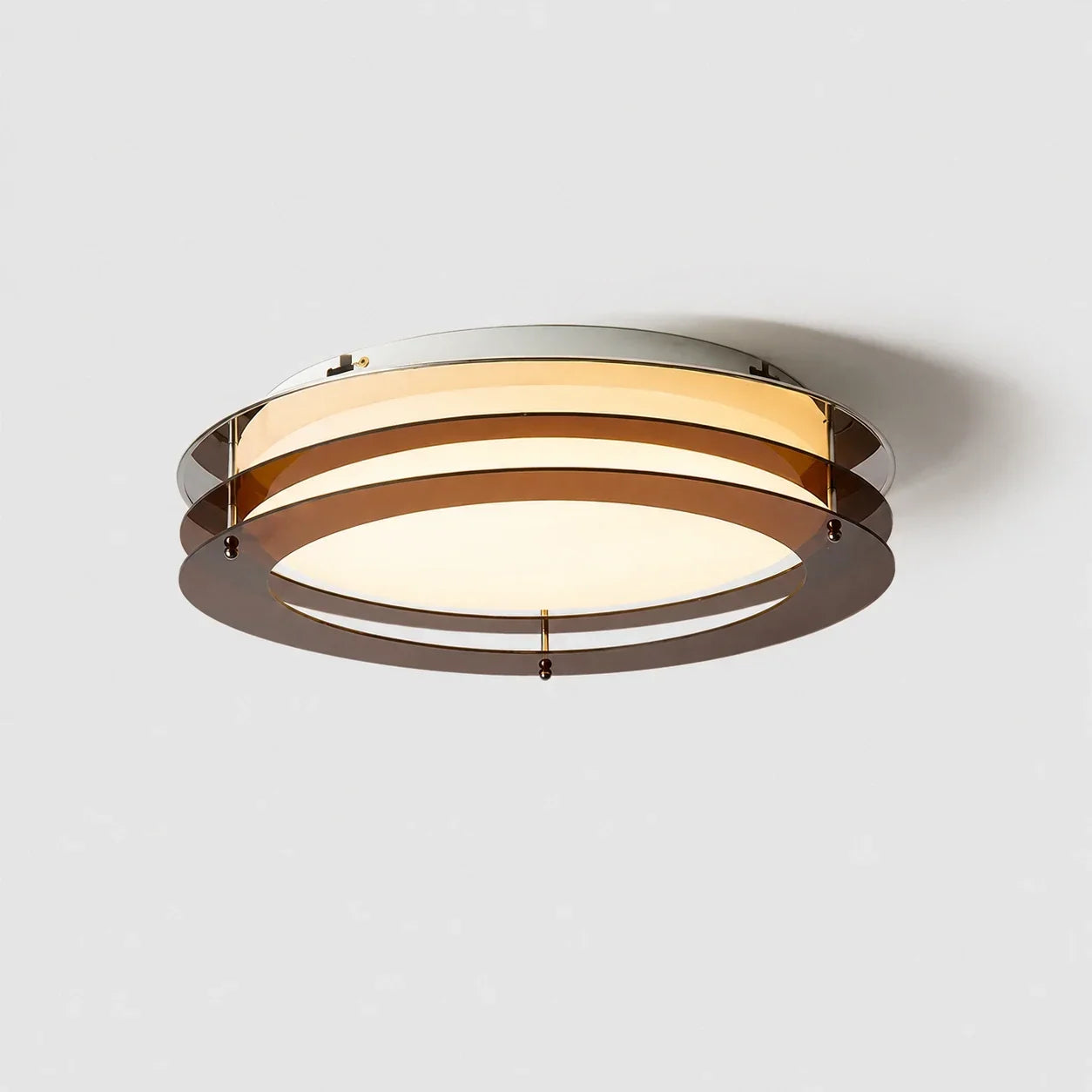 A modern circular layered LED ceiling light featuring translucent amber rings and a warm glowing flush mount diffuser, shown against a white background.