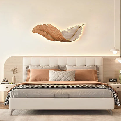 Horizontal orange and white LED feather wall lamp mounted above a modern upholstered bed, creating soft ambient lighting in a contemporary bedroom.