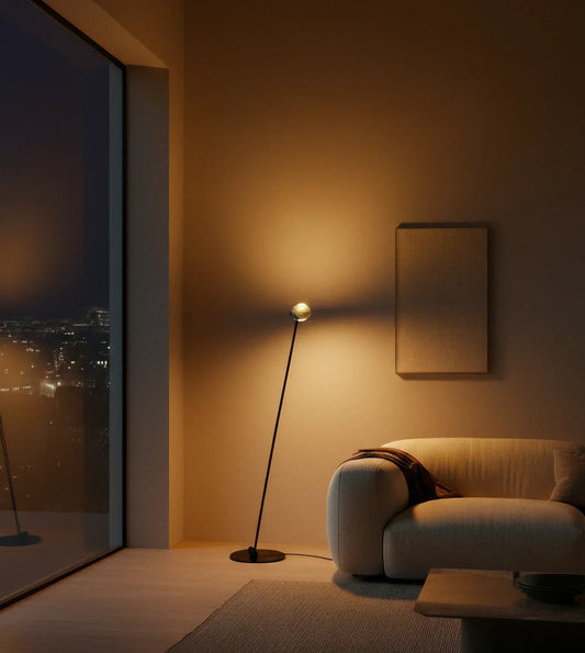 Twin-head LED floor lamp lighting a seating area at night