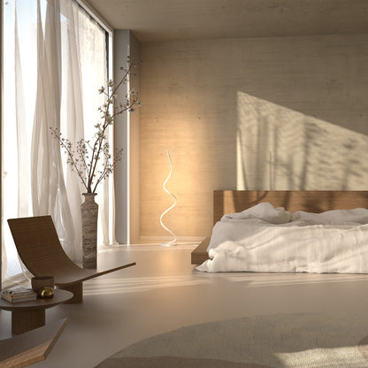 White spiral floor lamp beside a bed in daylight
