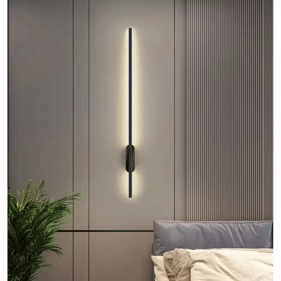 Slim LED wall light above a bedside table