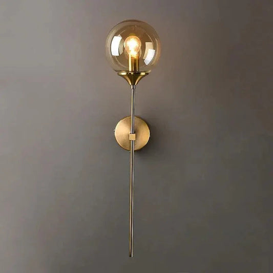 Brass stem wall light with amber glass globe