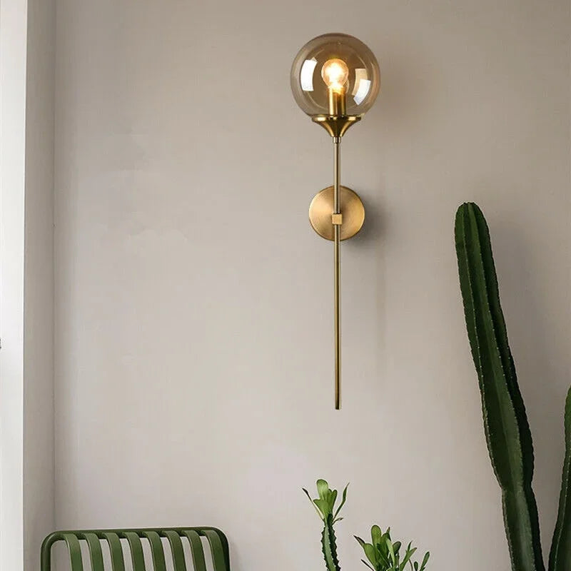 Amber globe wall light beside a cactus