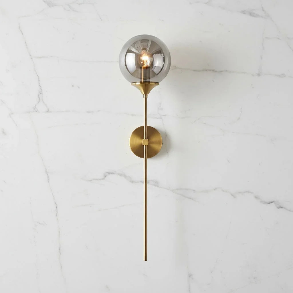 Smoke grey glass globe wall light with brass stem