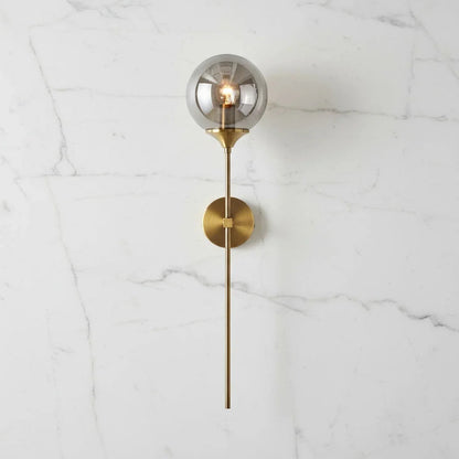 Smoke grey glass globe wall light with brass stem