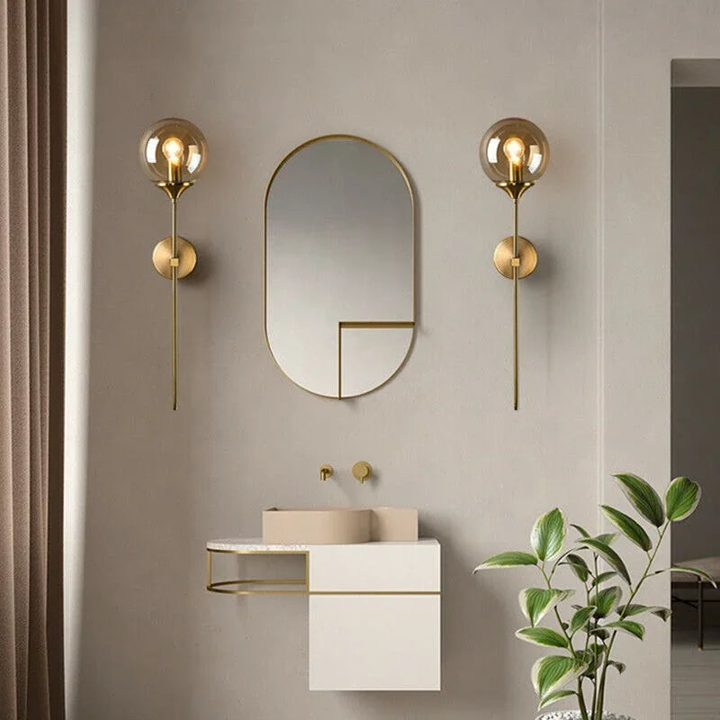 Pair of brass stem globe lights beside a mirror