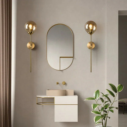 Pair of brass stem globe lights beside a mirror