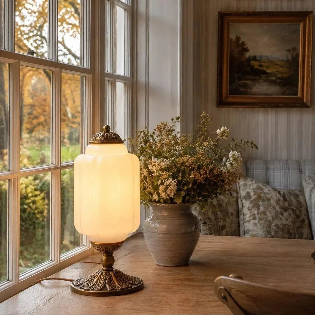 Illuminated frosted glass table lamp beside a window