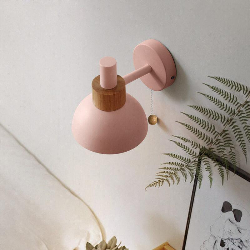 Pink metal wall sconce with globe shade