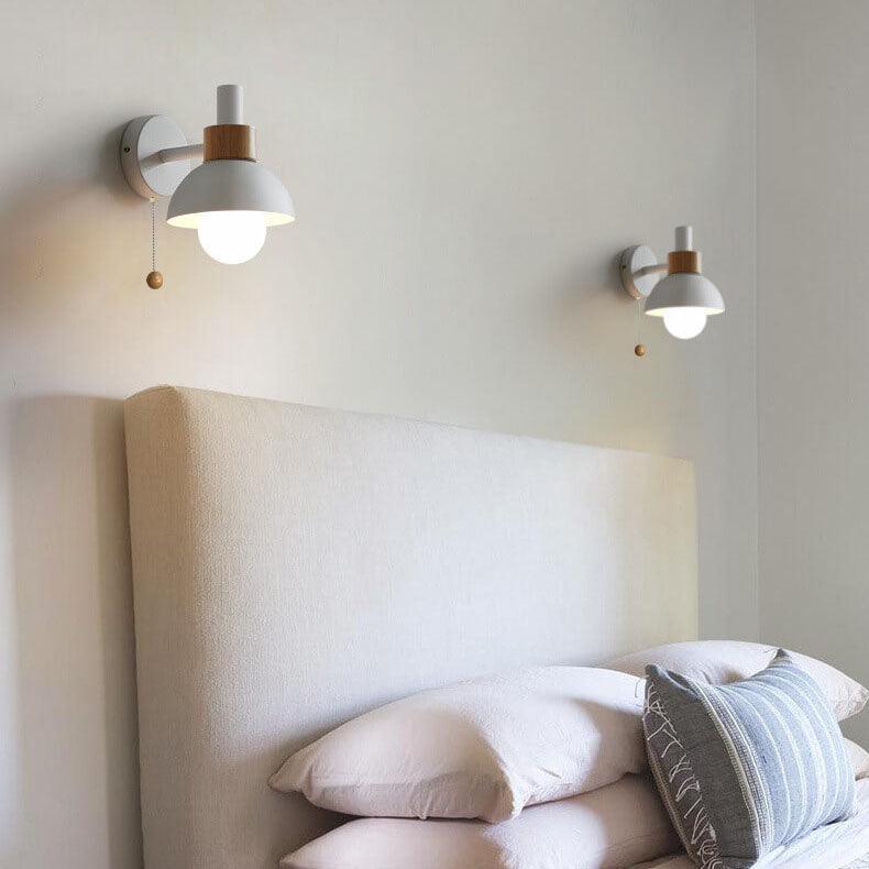 Pair of white globe wall lights beside a bed