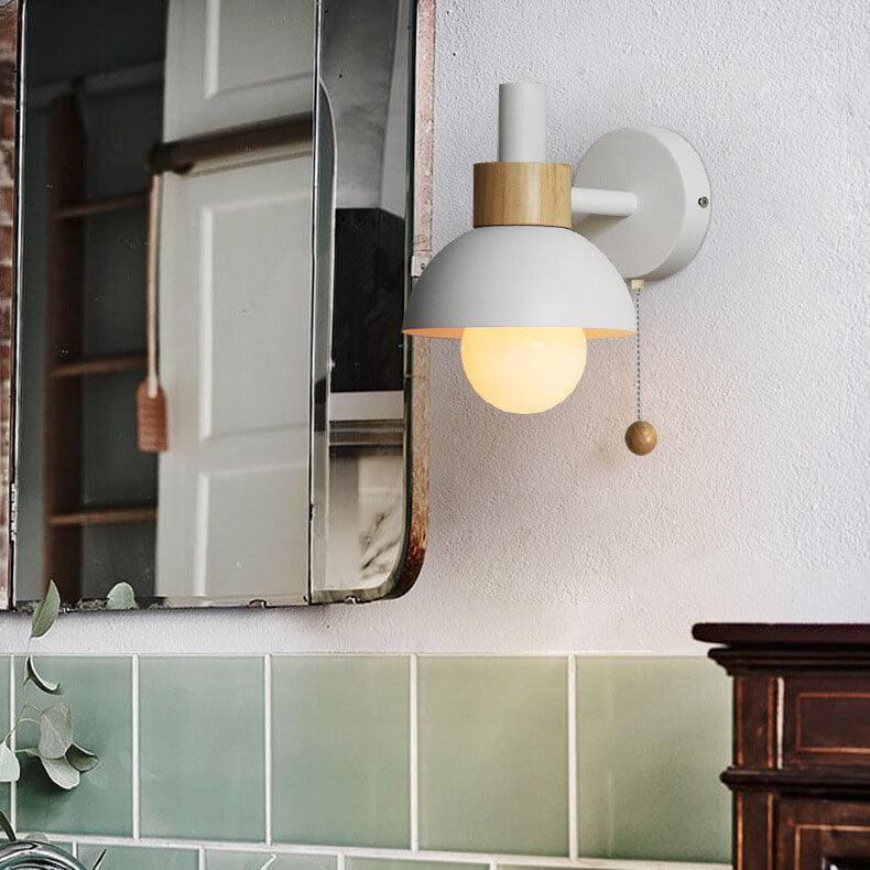 White globe wall sconce beside a mirror