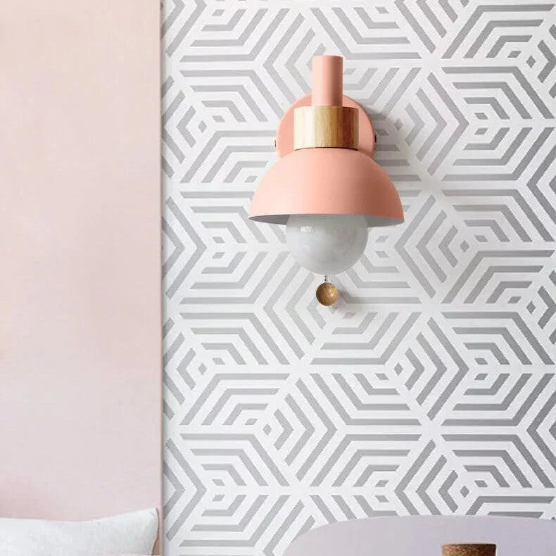 Pink globe wall sconce on a patterned wall