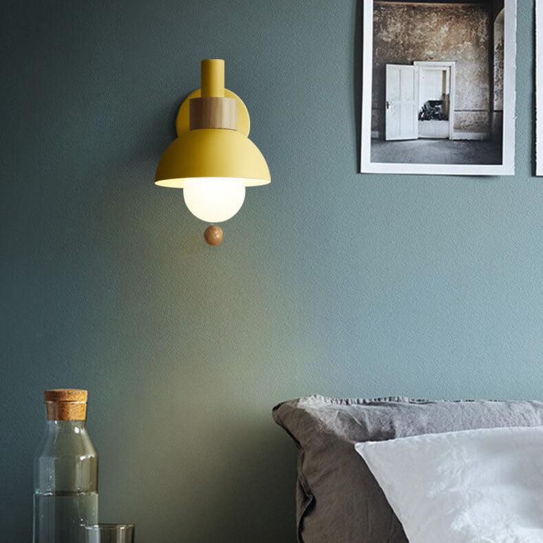 Yellow globe wall light above a bedside table